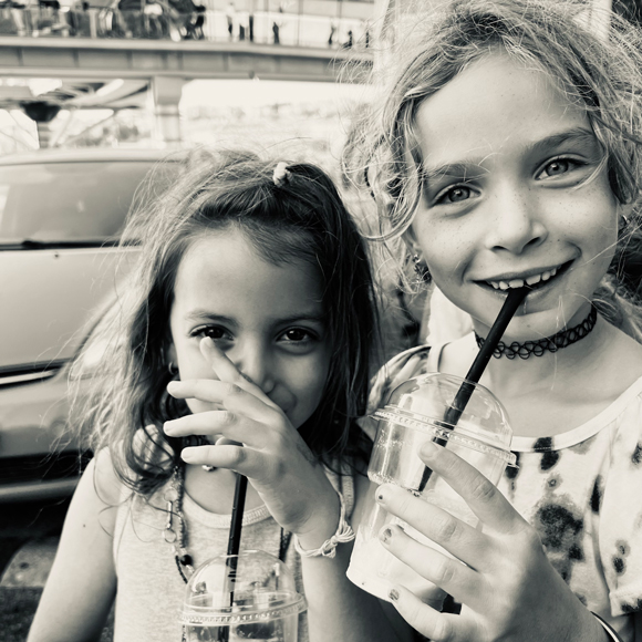 two girls drinks a shake