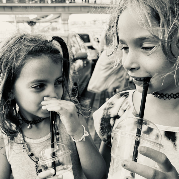 two girls drinks a shake